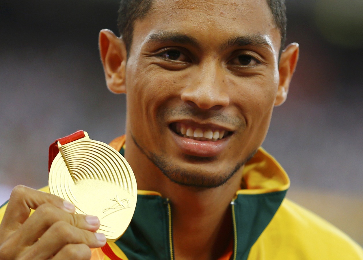 Wayde van Niekerk of South Africa presents his gold medal as he poses on the podium after the men's 400 metres final during the 15th IAAF World Championships at the National Stadium in Beijing
