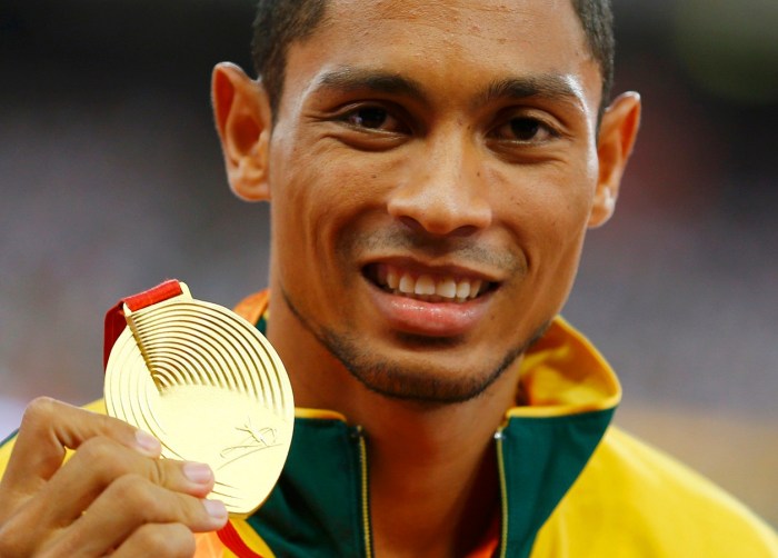 Wayde van Niekerk of South Africa presents his gold medal as he poses on the podium after the men's 400 metres final during the 15th IAAF World Championships at the National Stadium in Beijing